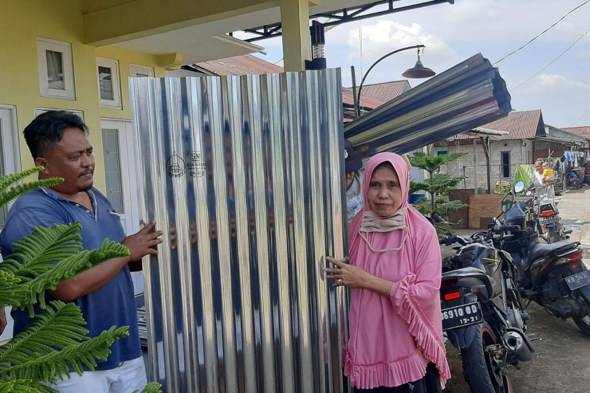 Raut wajah Khadijah sumringah saat menerima bantuan atap seng