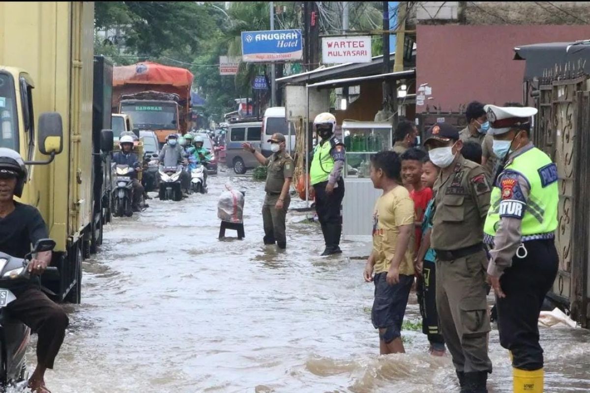 Luapan air dari saluran di jalan tol JORR 2 menimbulkan genangan di wilayah Benda