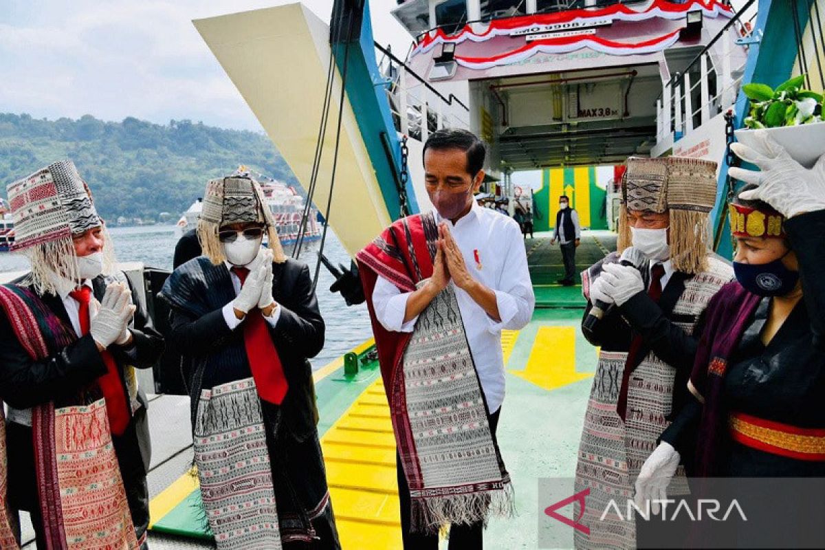 Presiden Jokowi berselempang Ulos Pinunsaan seberangi Danau Toba