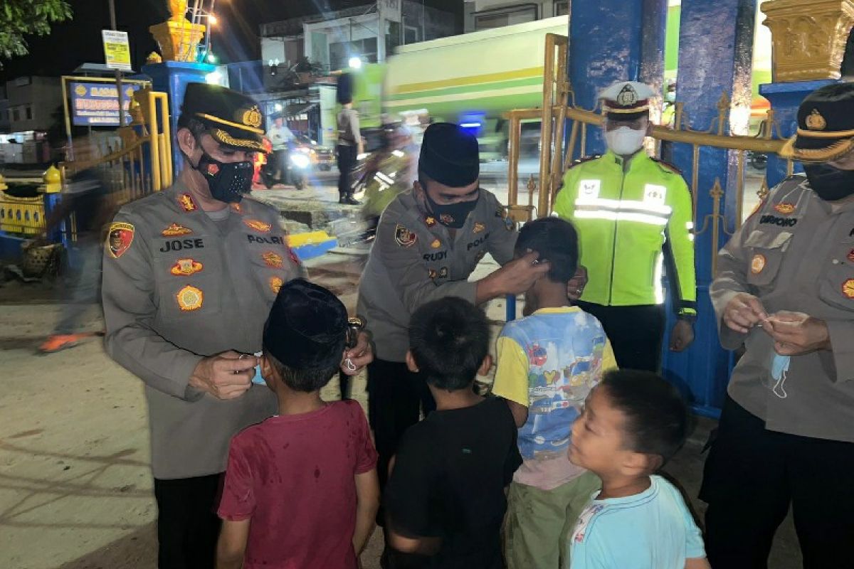 Kapolres Batubara pakaikan masker kepada anak hendak salat tarawih