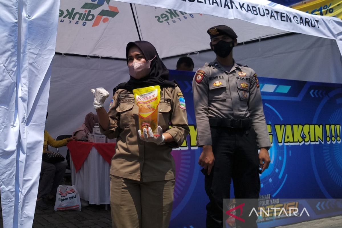 Warga ikuti vaksinasi COVID-19 di pusat kota Garut dapat minyak goreng