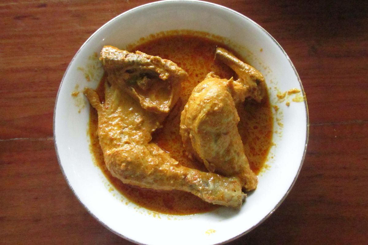 Menyajikan gulai ayam khas Padang