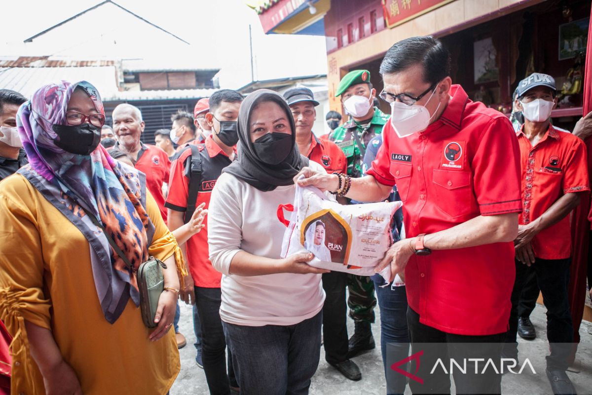 Yasonna membagikan beras bantuan bagi warga dari Puan Maharani