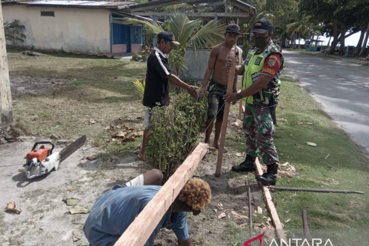 Babinsa Biak Timur bersama warga membuat pagar jalan desa