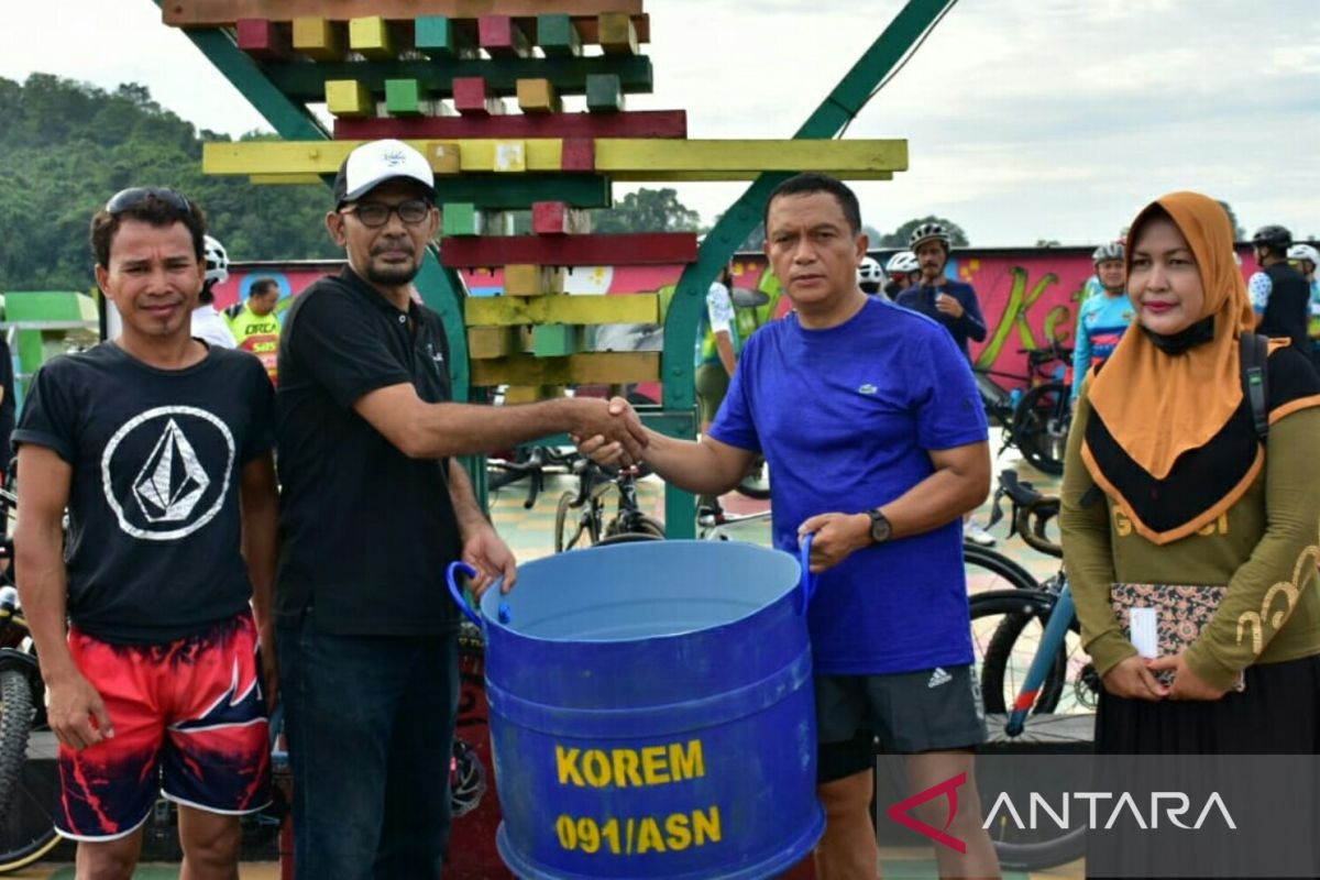 Prajurit Korem 091/ASN gowes sambil pungut sampah