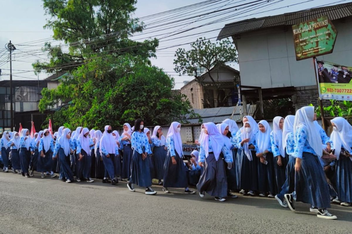 Siswa sekolah memadati pinggir jalan menuju lokasi pemakaman Eril