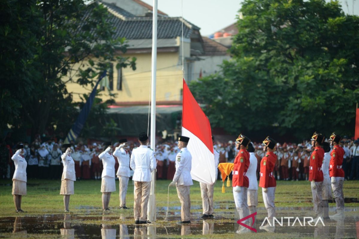 Upacara pengibaran bendera HUT RI di lapangan berlumpur di Tangerang