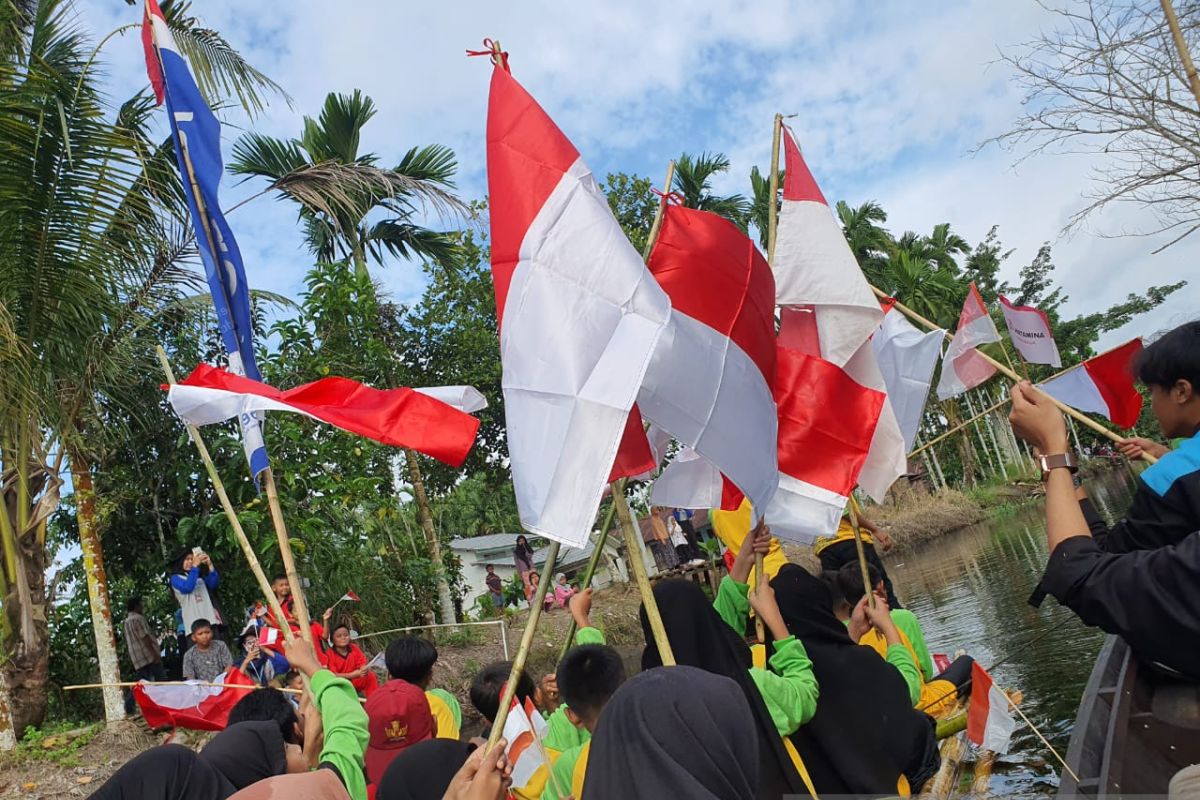 Ratusan anak kibarkan bendera di sepanjang sungai di Kubu Raya