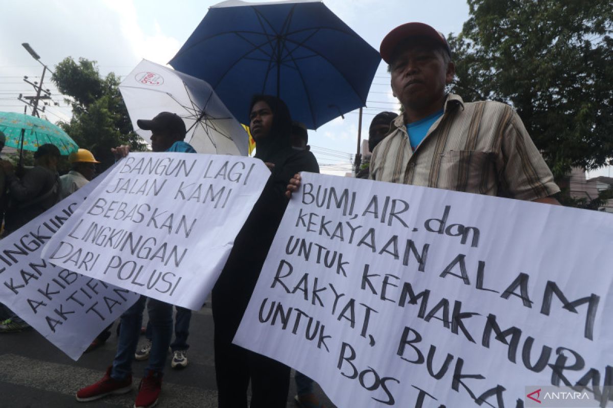 Demonstran menunjukkan spanduk menolak tambang pasir ilegal