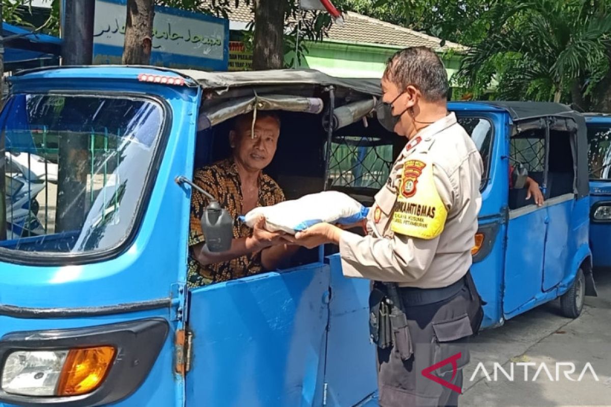 Polisi bagikan beras kepada puluhan pengemudi bajaj di Jakbar