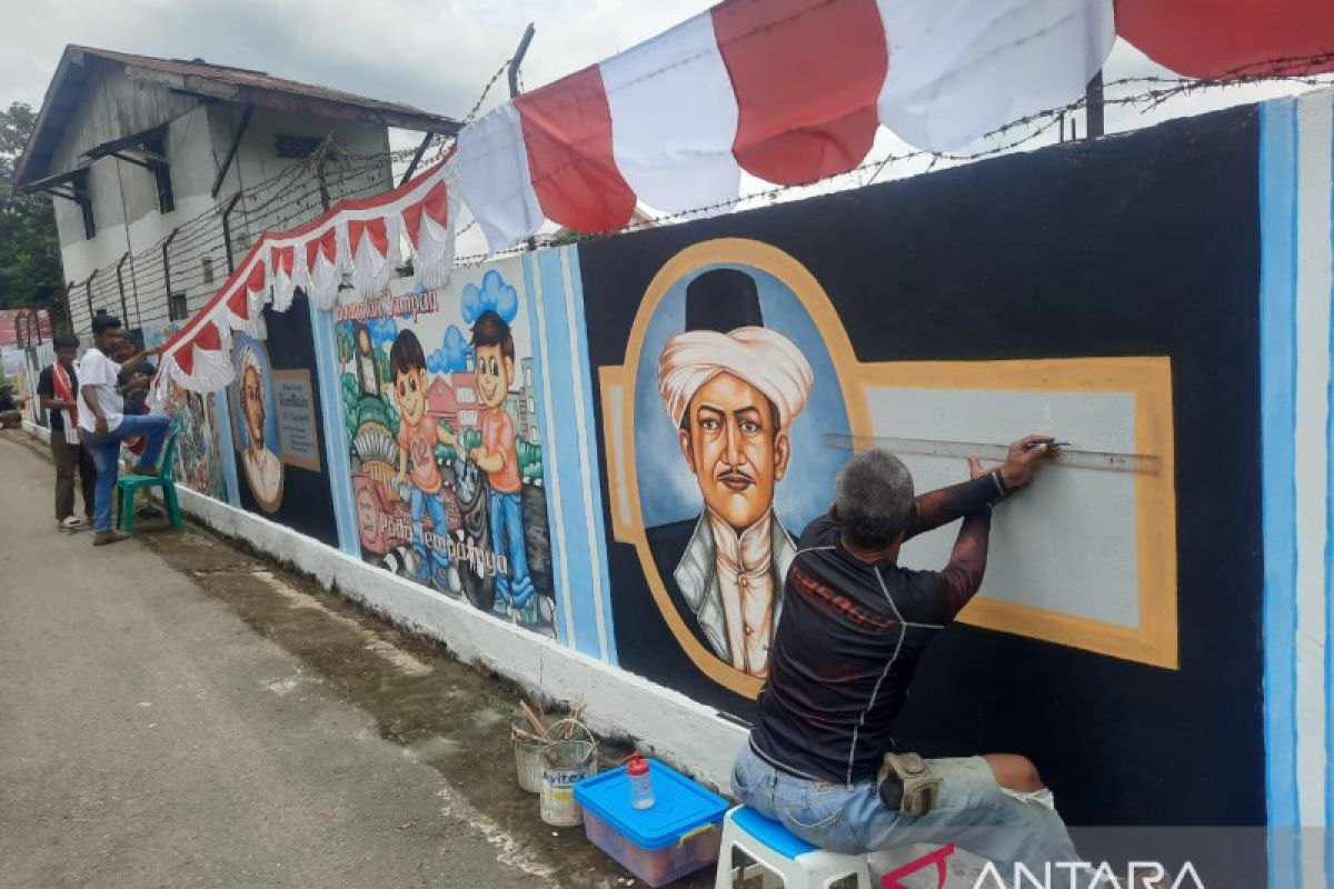 Seniman lukis mural wajah pahlawan di tembok sepanjang 65 meter