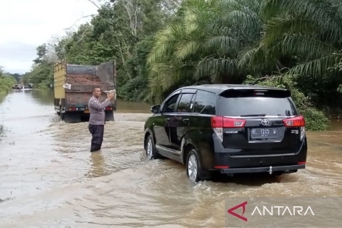 Personel Polres Aceh Barat bantu pengguna jalan di lokasi banjir