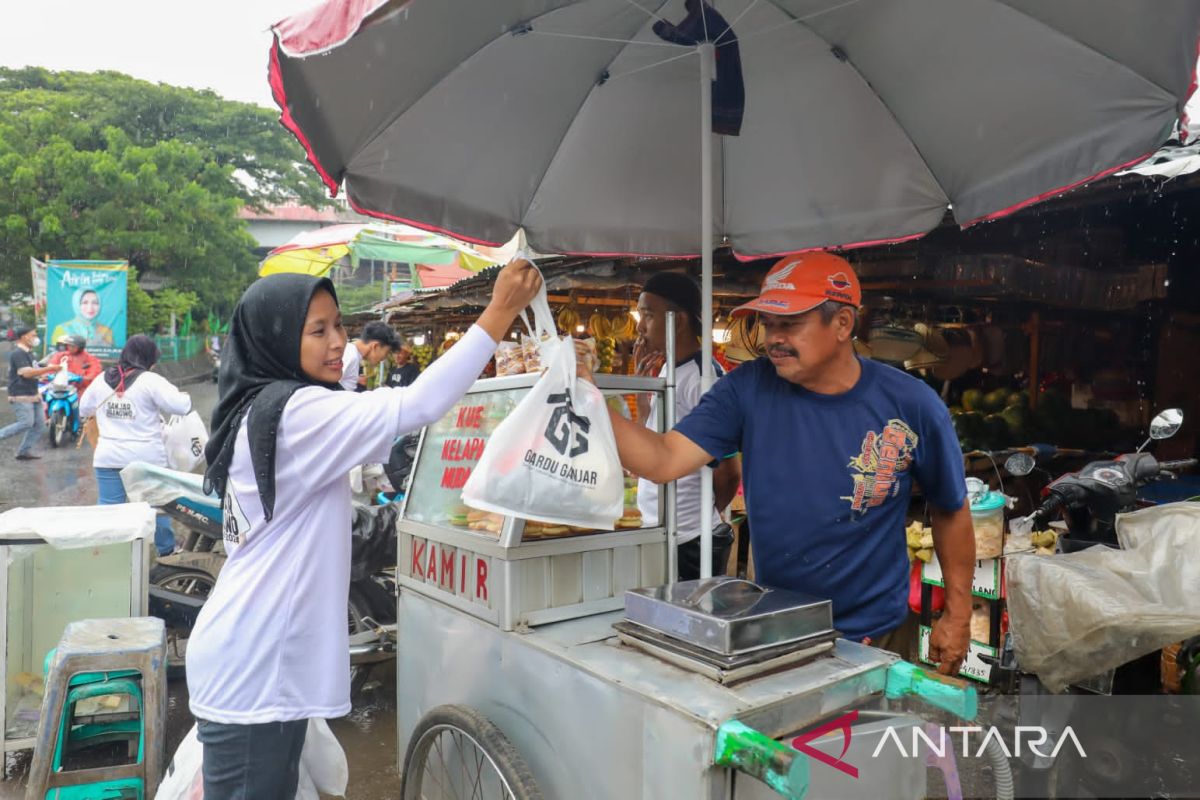 Hujan Tak Halangi Tekad Relawan Gardu Ganjar Bagikan Sembako ke Warga di Pasar Ciputat, Tangsel