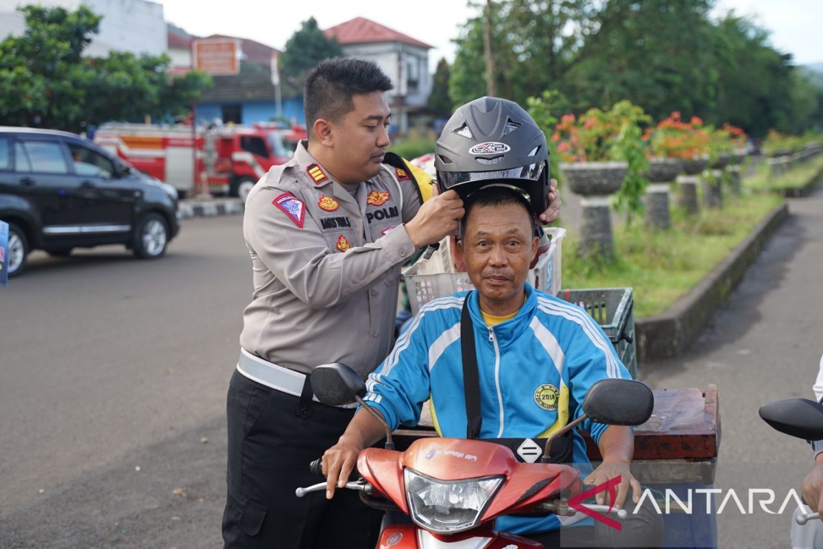 Satlantas Polres Sukabumi bagikan bunga dan helm gratis ke pemotor