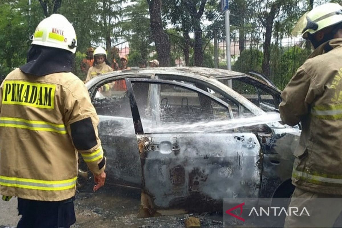 Sebuah mobil hangus terbakar di pintu keluar tol Bambu Apus