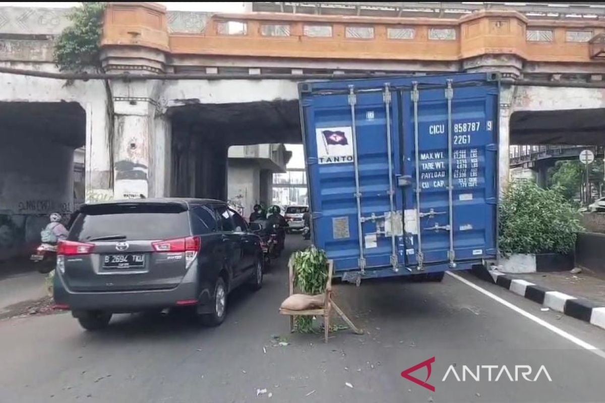 Truk kontainer tersangkut di kolong jembatan kereta di Matraman