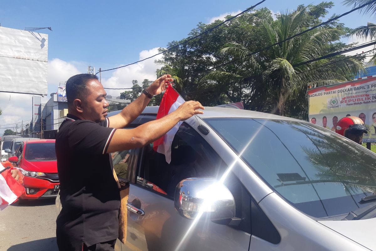 Jurnalis bersama PJ Bupati Jayapura bagikan Bendera Merah Putih
