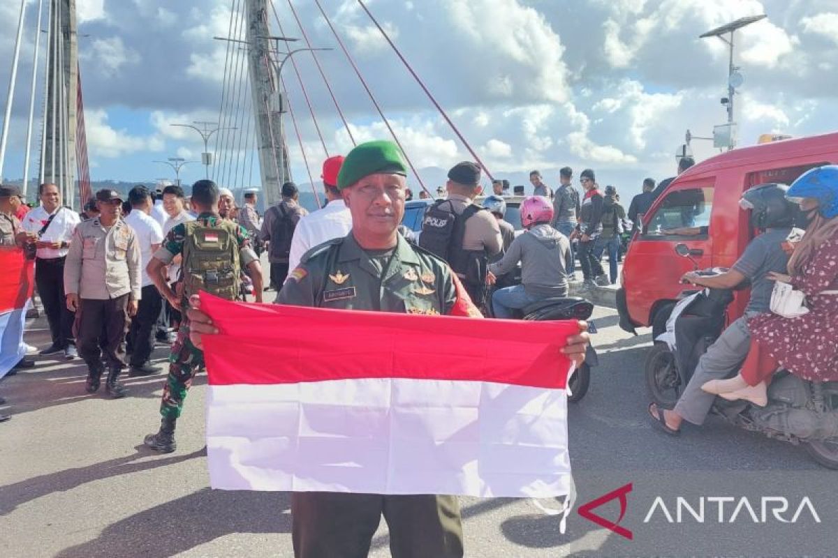 TNI bersama siswa bagikan bendera merah putih di ikon Kota Ambon
