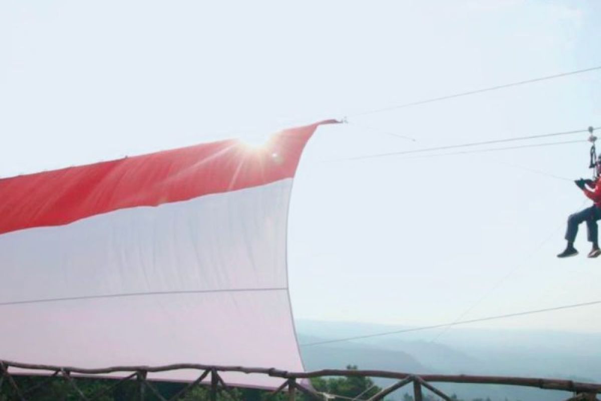 Bupati Subang bergelantungan bentangkan bendera Merah Putih raksasa di atas bukit
