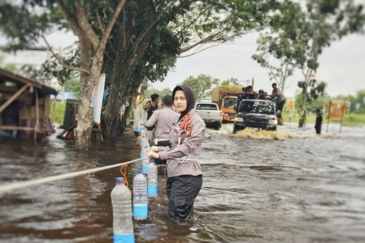 Riau police put up hazard warnings along flood-submerged roads