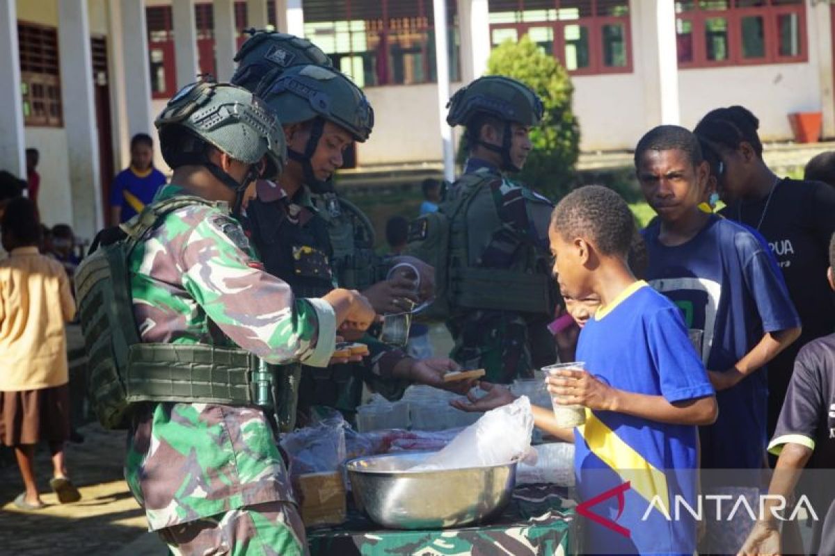 Prajurit TNI bagi bubur kancang gratis untuk anak-anak di Maybrat