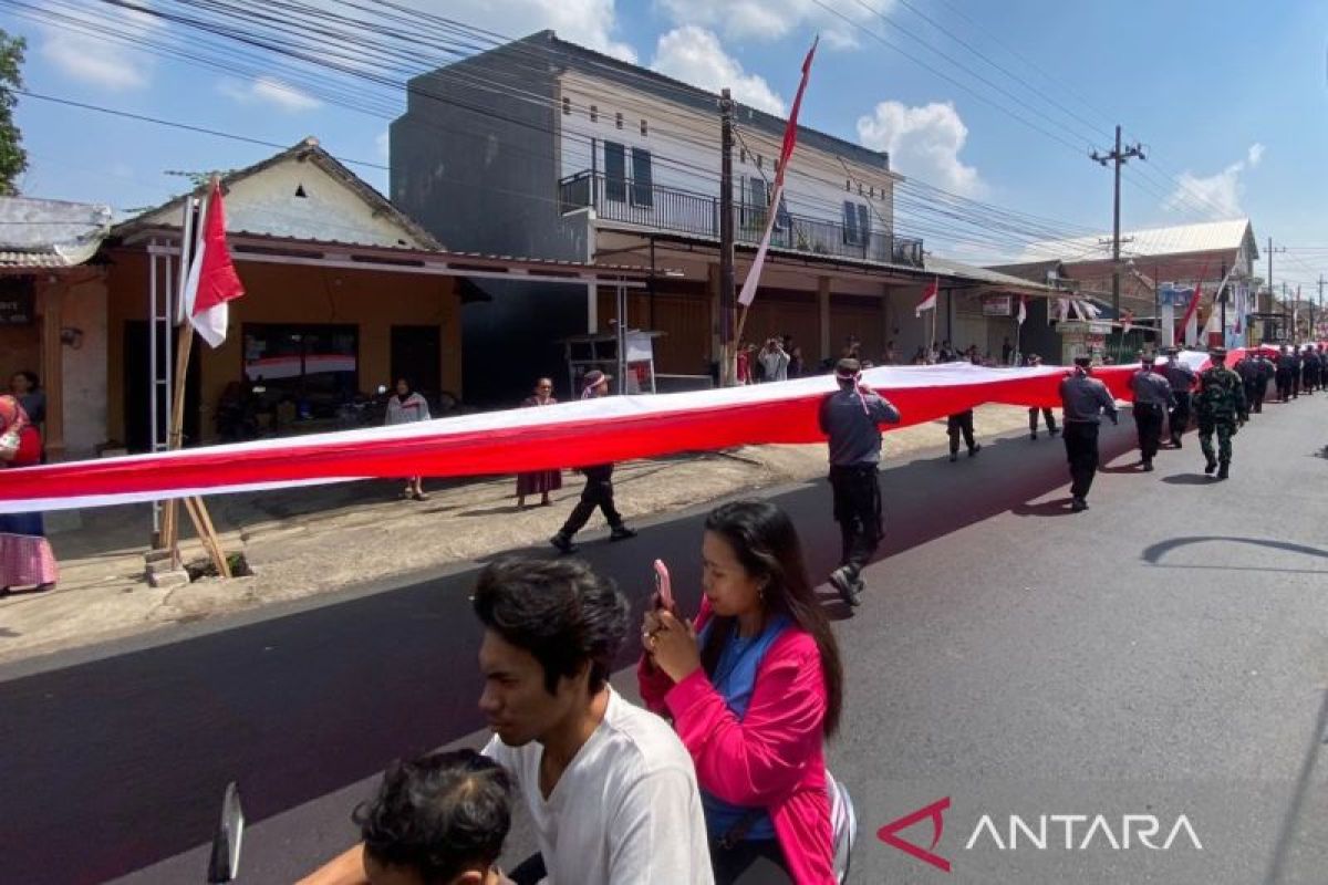 Puluhan petugas Linmas Kota Malang arak bendera merah putih berukuran raksasa