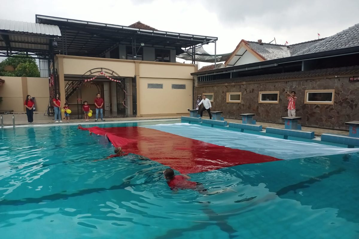 Perenang Tulungagung bentangkan bendera raksasa di atas kolam