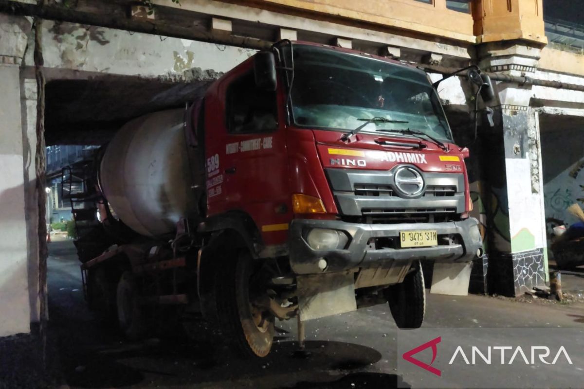 Truk molen tersangkut di kolong jembatan kereta