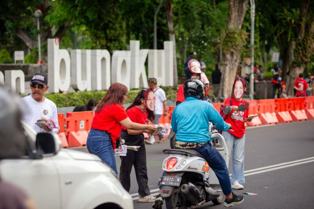 Pakai topeng Bu Risma, Relawan JAKA kampanye simpatik bagi-bagi bunga di Surabaya