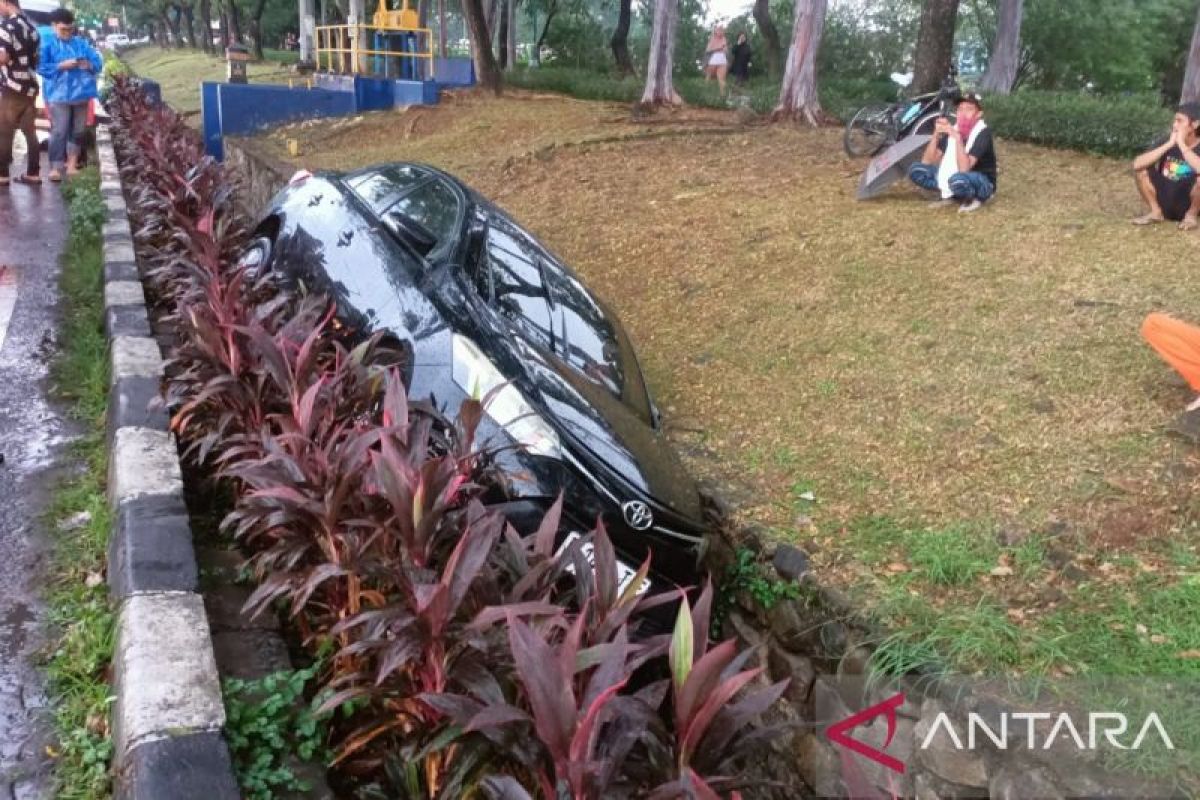 Sebuah mobil sedan terperosok ke saluran air dekat KBT