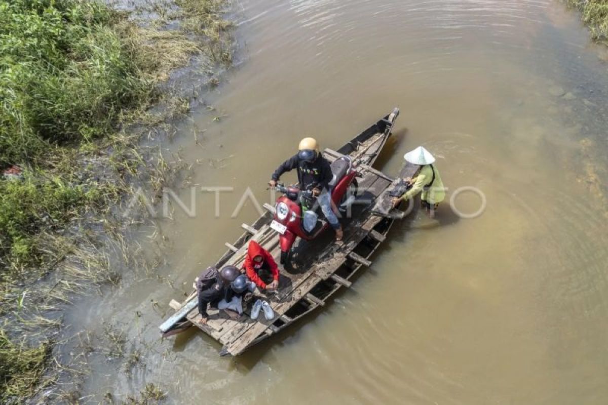 Jasa penyeberangan sepeda motor saat banjir