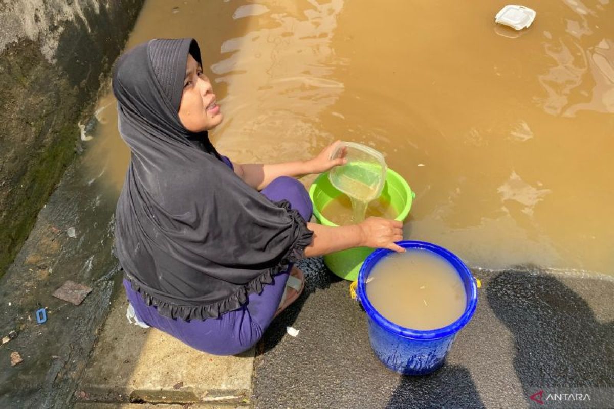 Kekurangan air bersih, warga Pengadegan cuci piring dengan air banjir
