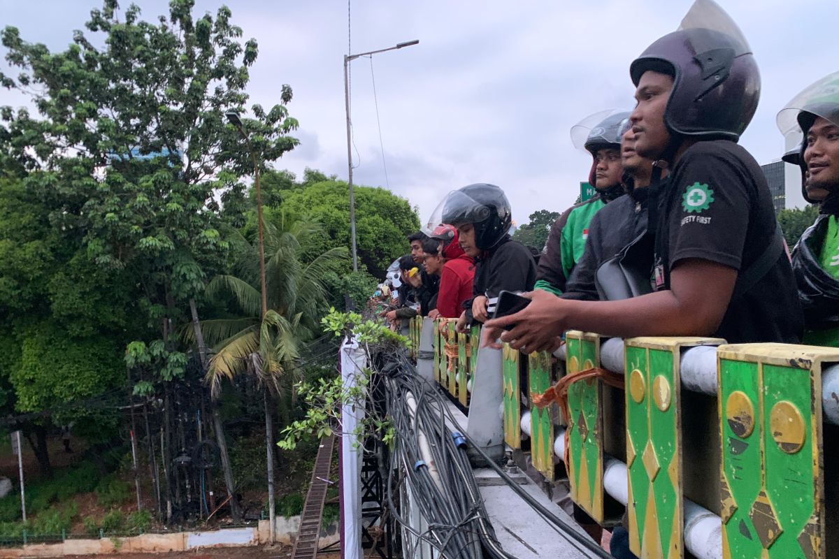 Puluhan pengendara asyik menonton bentrokan petugas dengan massa aksi