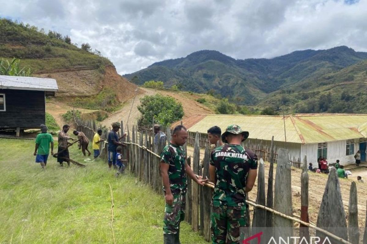 Satgas TNI Yonif 511/DY gotong royong membangun pagar Puskesmas Balingga