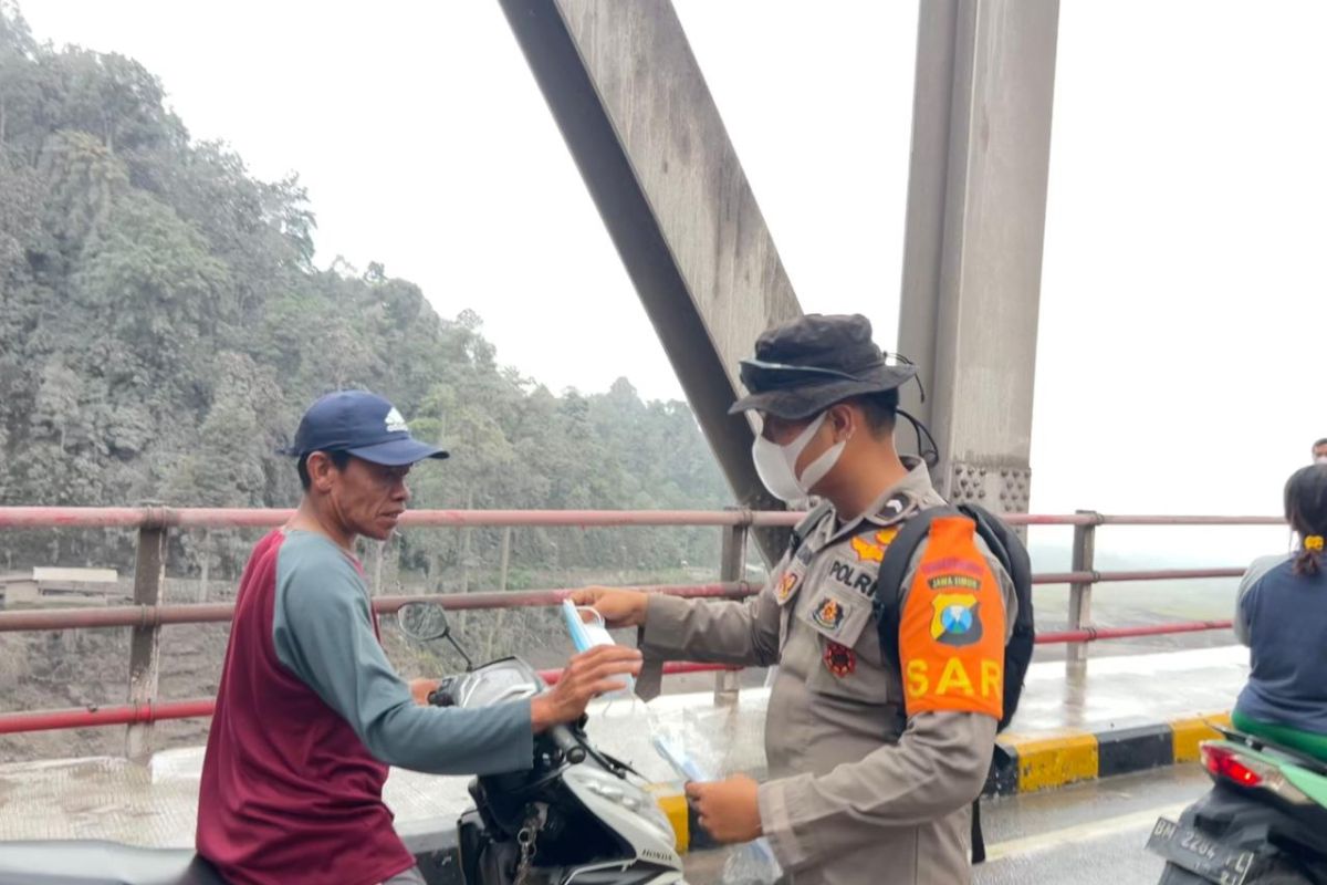Mount Semeru eruption: Police hand out masks as ash covers key route