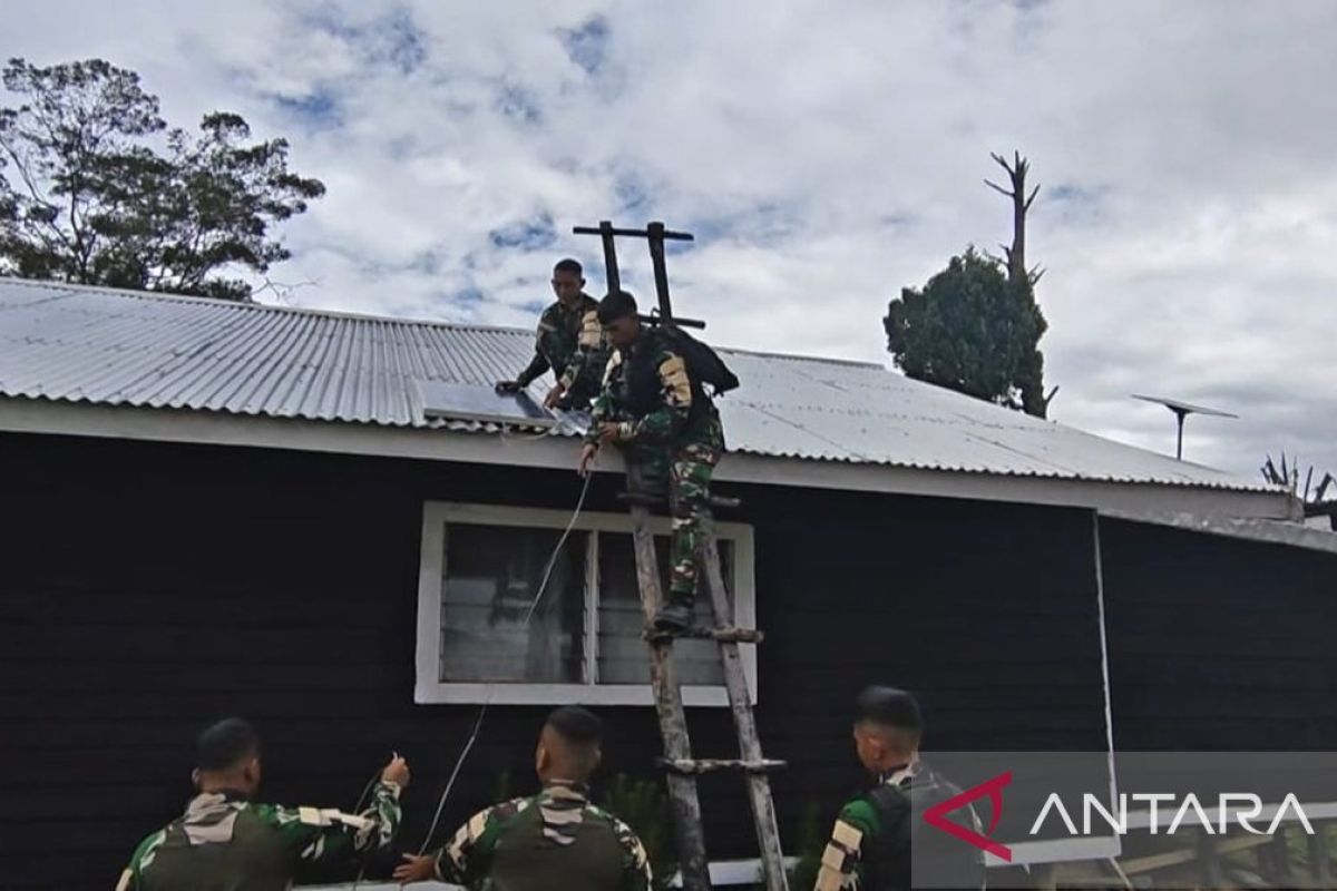 Prajurit TNI Satgas Yonif 511 memperbaiki lampu tenaga surya Gereja Popome