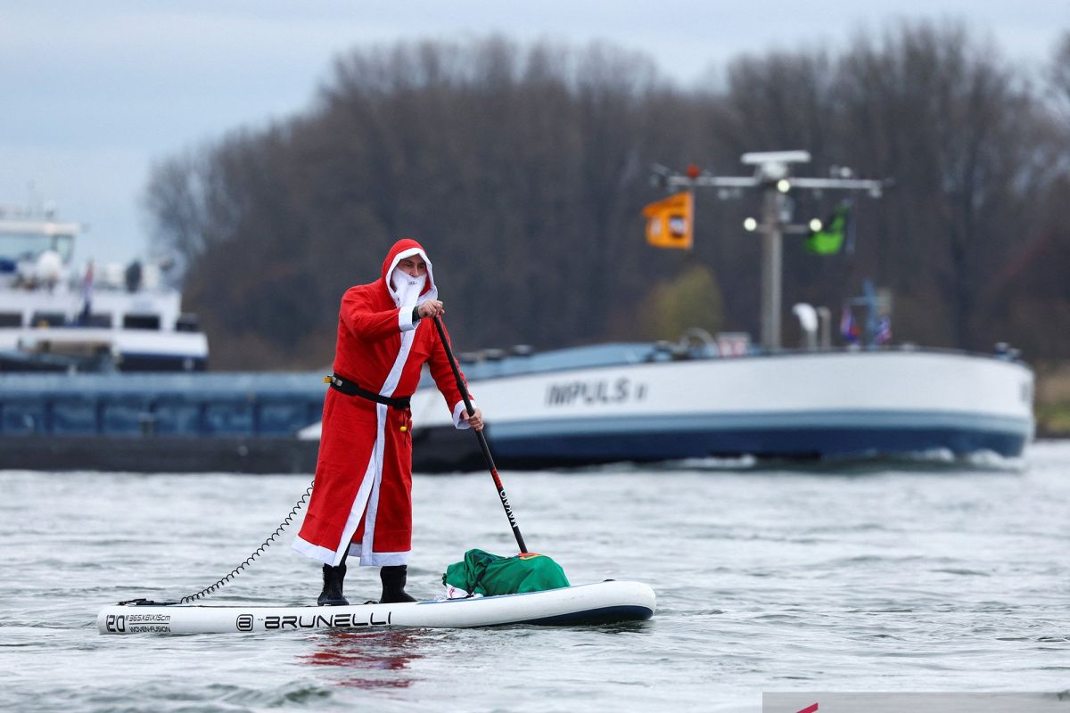 Saat Sinterklas bermain papan seluncur di atas sungai