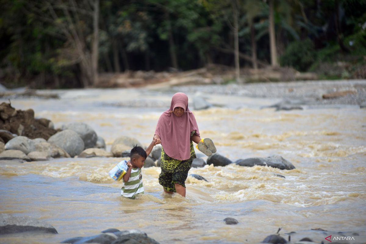 Ibu-ibu seberangi Sungai Batang Kuranji di Padang