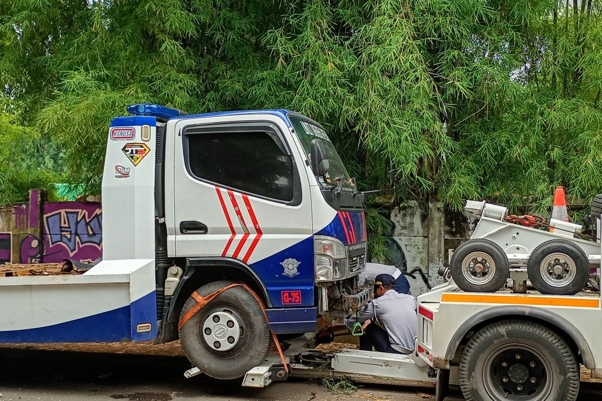 Parkir di bahu jalan, mobil towing milik Kepolisian diderek Sudinhub