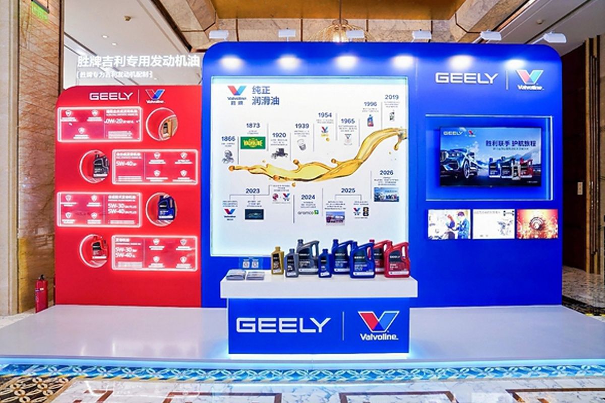 A display booth featuring Valvoline GEELY collaboration, showcasing co-developed lubricants and a timeline of their partnership, with product bottles arranged on a central table. (Ảnh: Antara News)