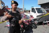 Polisi menjaga barang bukti saat ungkap kasus penggelapan kendaraan bermotor di PT Terminal Petikemas Surabaya, Surabaya, Jawa Timur, Jumat (19/7/2024). Polres Pelabuhan Tanjung Perak Surabaya menangkap tiga tersangka atas kasus dugaan penggelapan kendaraan bermotor dan pengirimannya ke negara tujuan Timor Leste serta mengamankan sejumlah barang bukti di antaranya dua mobil dan 34 sepeda motor. Antara Jatim/Didik Suhartono/um