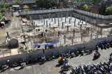 Denpasar (Antara Bali) - Beberapa pengendara sepeda motor melintas di samping sentral parkir Pasar Badung yang kini masih dalam proyek pembangunannya di Denpasar, Bali, Selasa (31/8). Pembangunan sentral parkir itu untuk mengurangi kemacetan jalan raya sekitarnya sekaligus penataan pasar yang ditargetkan menjadi salah satu daerah wisata dalam kota atau 