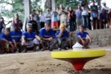 Singaraja (Antara Bali) - Salah satu kelompok pemain adu gangsing memperhatikan putaran gasingnya di arena adu gasing Desa Gesing, Kecamatan Banjar, Singaraja, Bali, Jumat (24/9). Permainan tradisional yang diwarisi sejak tahun 60-an di desa itu kini mulai dikembangkan menjadi salah satu obyek wisata unik di kawasan Bali Utara. FOTO ANTARA/Kadek Swarna/10.