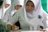 BANJARMASIN 24/1 - TRY OUT KEDUA. Siswa SMKN 3 Banjarmasin sedang menyelesaikan soal Matematika pada try out ujian nasional kedua yang diselenggarakan sekolah, Senin (24/1). Pada try out pertama yang diselenggarakan Dinas Pendididikan Provinsi Kalimantan Selatan, Desember 2010,  hanya 20 persen siswa SMK dan 2 persen siswa SMA yang memenuhi standar nilai kelulusan, sehingga masing-masing sekolah berupaya meningkatkan kemampuan siswa menghadapi Ujian Nasional 2011 mendatang. Foto Antara/Herry Murdy Hermawan