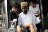 Denpasar (Antara Bali) - Tersangka teroris, Umar Patek (tengah) turun dari kendaraan polisi saat digiring ke Mapolda Bali, Rabu (19/10). Umar Patek bersama beberapa narapidana bom Bali I dibawa ke Bali untuk menjalani pemeriksaan dan rekonstruksi. FOTO ANTARA/Nyoman Budhiana/11.