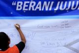 Jakarta (Antara Bali) - Seorang anak sekolah menuliskan pesan di spanduk anti korupsi dalam acara SPEAK Festival yang bertajuk " Berani Jujur Berani Hebat" yang di gelar di Lapangan Blok S, Jakarta, Sabtu (10/12). Festival yang di prakarsai oleh SPEAK (Suara Pemuda Anti Korupsi) ini mengajak generasi muda untuk menyebarkan virus anti korupsi dan mempraktekan kejujuran serta meningkatkan kesadaran akan bahaya korupsi. FOTO ANTARA/Agus Apriyanto/11.