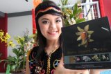 Banjarmasin, 5/12 - PESONA ANGGREK MERATUS - Model berpakaian Adat Dayak menunjukkan buku Pesona Anggrek Meratus yang diluncurkan DPD PAI Kalimantan Selatan pada Meratus Orchid Show 2011 di Taher Square Banjarmasin, Senin (5/12). Buku Pesona Anggrek Meratus menggambarkan kekayaan tanaman anggrek yang dimiliki Kalimantan Selatan. Diperkirakan 2500 dari 4000 jenis anggrek di Indonesia terdapat di Kalimantan Selatan dan beberapa diantaranya sudah langka. Foto ANTARA/Herry Murdy Hermawan/B