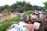 Solo (Antara Bali) - Sejumlah warga korban banjir beserta barang milik mereka mengungsi di atas tanggul Sungai Bengawan Solo, Kampung Mojo, Solo, Jateng, Senin (2/1). Hujan deras selama 6 jam menyebabkan sungai Bengawan Solo meluap dan membanjiri pemukiman warga di sekitar bantaran sungai tersebut. FOTO ANTARA/Akbar Nugroho Gumay/12.