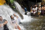 Tegallalang (Antara Bali) - Beberapa warga antre untuk "Melukat" atau mengguyur diri dengan air terjun bertepatan dengan bulan purnama di Desa Sebatu, Tegallalang, Bali, Selasa (7/2). Air terjun di dekat sumber mata air itu diyakini dapat menyembuhkan berbagai penyakit dan memberi kejernihan/kesucian pikiran. FOTO ANTARA/Nyoman Budhiana/12.