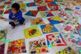 Batu (Antara Bali) - Seorang peserta meletakkan layang-layang lukisannya di ruang penjurian dalam Festival Melukis Layang-layang di TK Al Irsyad, Batu, Jawa Timur, Sabtu (10/3). Kegiatan untuk memacu kreatifitas anak-anak tersebut diikuti ratusan peserta. FOTO ANTARA/Ari Bowo Sucipto/2012.